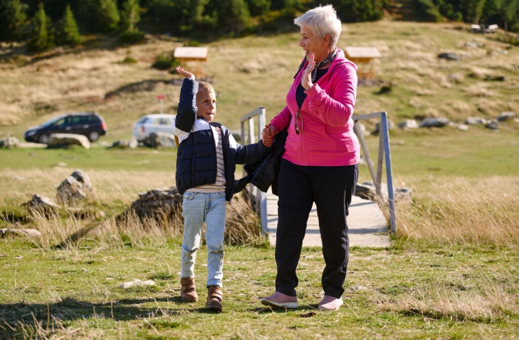 A grandchild staying involved with their grandparent in a meaningful way by going for a walk outdoors together.