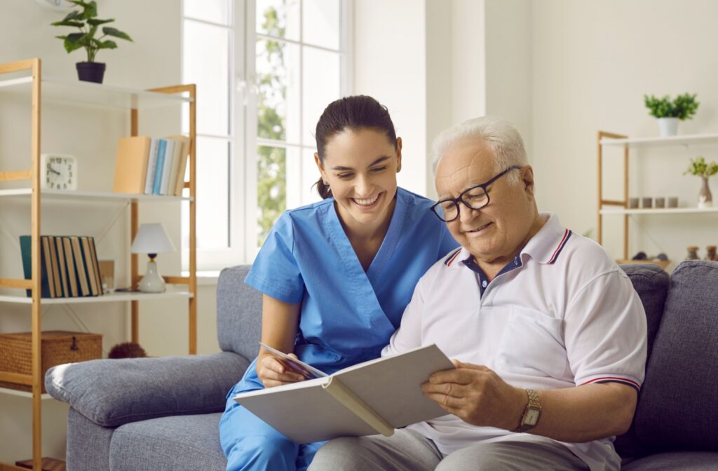 A senior adult and a nurse looking at a photo book together in a personal care community.