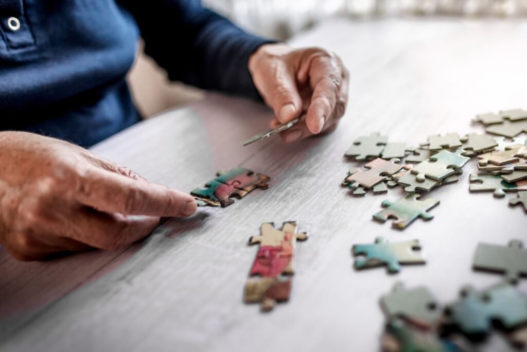 Close up of a senior working on a puzzle.