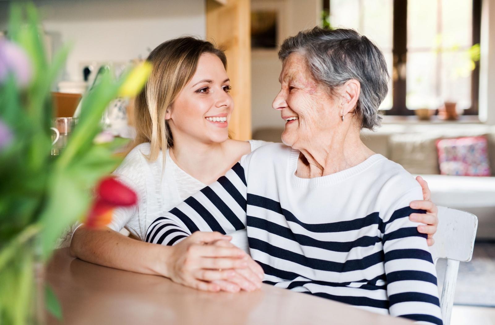 a young woman hugs her senior parent