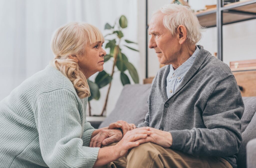 An older adult comforts their senior loved one with dementia